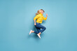 © deagreez - Full length photo of pretty blond lady jumping high rushing mall discounts low prices shopping wear knitted yellow pullover jeans isolated blue color background