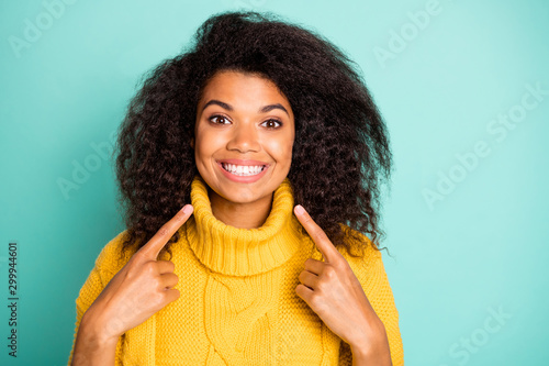 Cuadros en Lienzo Closeup photo of amazing dark skin curly lady indicating fingers on perfect teet