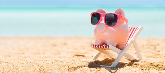 Pink Piggybank On Deck Chair Over The Sandy Beach