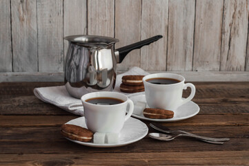 Coffee on a wooden table in white mugs