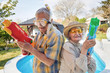 © luckybusiness - Modern Senior people have fun playing with  water gun.