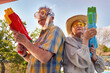 canvas print picture - Modern Senior couple have fun playing with  water gun.