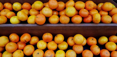 Wall Mural - Fresh orange on brown wooden shelf for sale at organic fruit market or supermarket - Harvest, Diet food and Agriculture product concept 