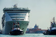 Modern white cruise ship Costa Victoria with tug boats and pilot in Giudecca Canal Grande with skyline of Venice Venezia, Italy with basilica and buildings enroute to port and cruise terminal