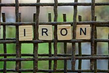 Word Iron  Made Of Wooden Letters On An  Rusty Brown Grate