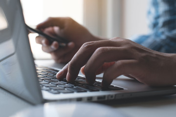 Businessman using mobile smart phone and laptop computer