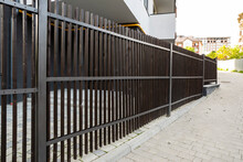 Wooden Fence From Vertical Boards And On A Metal Frame In The City
