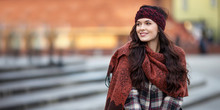 Beautiful Joyful Woman Portrait In A City. Smiling  Girl Wearing Warm Clothes And Hat  In Winter Or Autumn. Christmas Time With  Unfocus Lights On Backgrounde. Copy Space