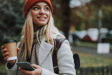 Young Girl With Coffee To Go Holding Smartphone
