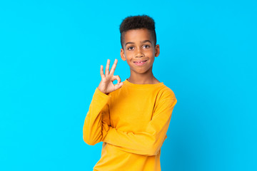 Wall Mural - African American boy over isolated blue background showing ok sign with fingers