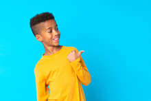 African American Boy Over Isolated Blue Background Pointing To The Side To Present A Product