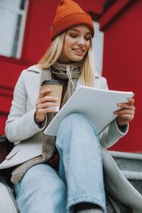 Wall Mural - Young woman sitting with coffee and copybook