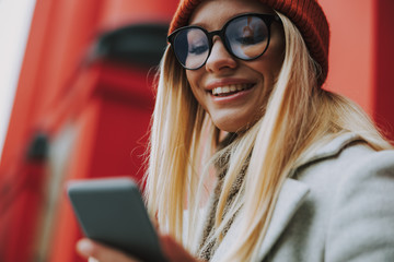 Young woman with modern smartphone smiling wide