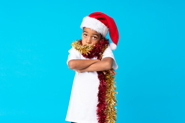 Poster - African American boy with christmas hat making doubts gesture while lifting the shoulders