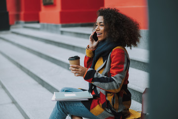 Wall Mural - Afro American woman is talking on smartphone