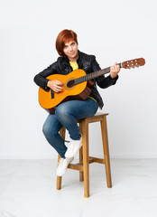 Redhead woman playing guitar