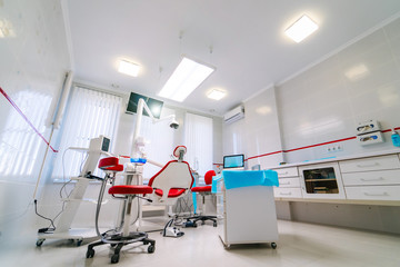 Dentistry, medicine, medical equipment and stomatology concept - interior of new modern dental clinic office with chair.