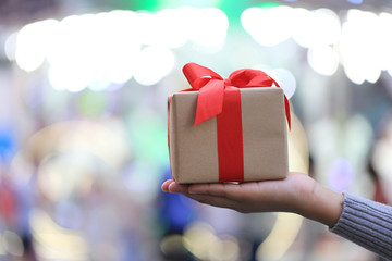 Female hands holding gift box with red ribbon for Christmas and New Year's Day or Greeting season, Valentines day