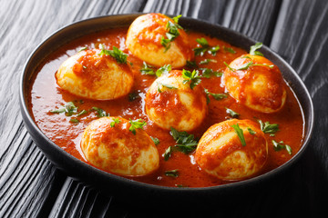 Wall Mural - Boiled eggs cooked in spicy curry sauce close-up in a plate. horizontal