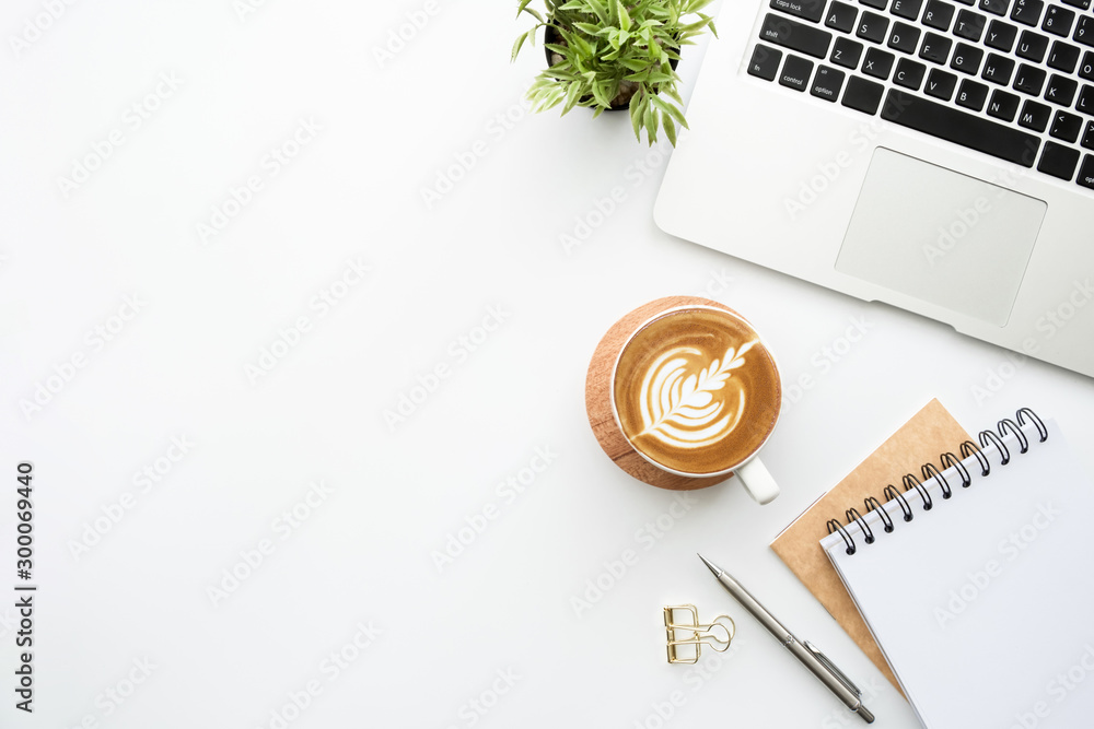 White minimalist office desk table with laptoo computer, notebooks with pen, cup of latte coffee and supplies. Top view with copy space, flat lay. - obrazy, fototapety, plakaty 