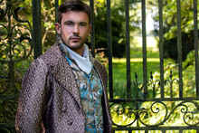 Portrait Of Handsome Gentleman Dressed In Vintage Costume Standing In Stately Home Courtyard With Railings In Background
