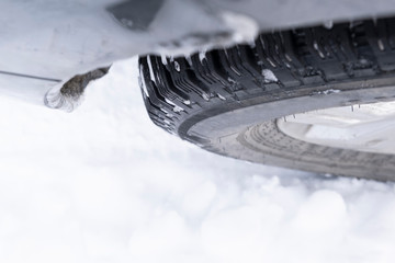 closeup of a car wheel with winter tire in snow