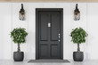© ImageFlow - Black front door of white house with trees