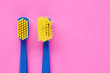 Old and new toothbrush in contrast on pink background with copy space