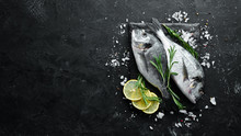 Raw Dorado Fish With Lemon And Spices On A Black Background. Top View. Free Space For Your Text.
