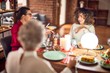 © Krakenimages.com - Beautiful group of women smiling happy and confident. Eating roasted turkey and serving wine on cup celebrating christmas at home