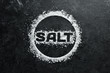 © Yaruniv-Studio - Sea salt with the inscription SALT. On a black stone background. Spa treatments. Top view. Free space for your text.