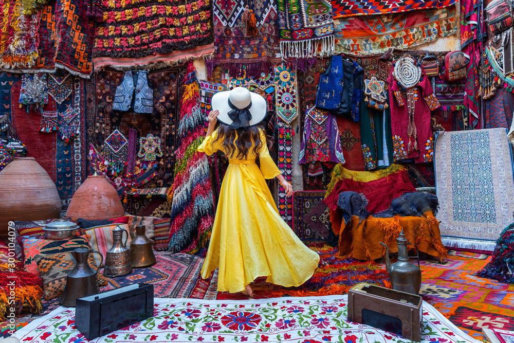 Beautiful girl at traditional carpet shop in Goreme city, Cappadocia in Turkey. - obrazy, fototapety, plakaty 