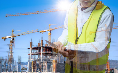 Wall Mural - The architect is working and holding a blueprint in hand to inspect the  construction site  according to plan, conceptual picture of new building business industry.