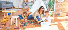 Beautiful Teacher And Group Of Toddlers Playing Around Lots Of Toys At Kindergarten