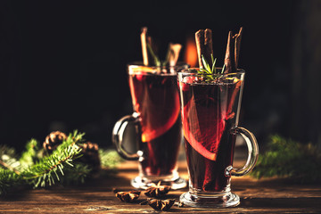 Mulled wine with spices in glasses on a rustic wooden table. Winter drink traditional for the Christmas holidays.