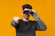 © luismolinero - Young man over isolated background with black binoculars