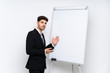 © luismolinero - Young businessman giving a presentation on white board giving a presentation on white board