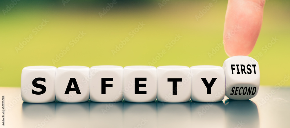 Hand turns a dice and changes the expression "safety second" to "safety first" - obrazy, fototapety, plakaty 