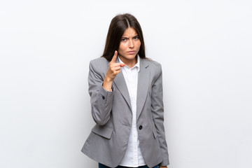 Young business woman over isolated white background frustrated and pointing to the front