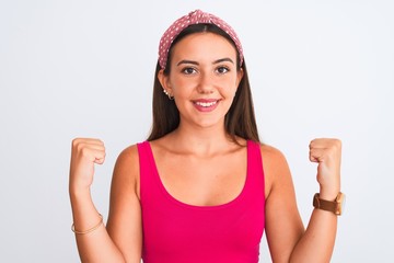 Young beautiful girl wearing pink casual t-shirt and diadem over isolated white background celebrating surprised and amazed for success with arms raised and open eyes. Winner concept.