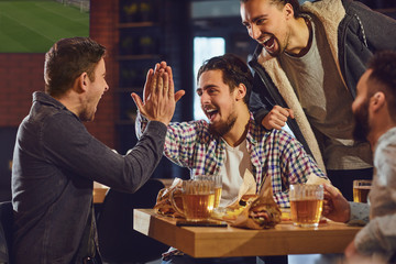 Wall Mural - Friends talk, drink beer in a bar.