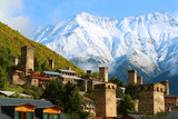 Fototapeta  - Stunning View of Medieval Svan Tower-houses against the Snow-capped Caucasus Mountain in Mestia, Svaneti Region of Georgia