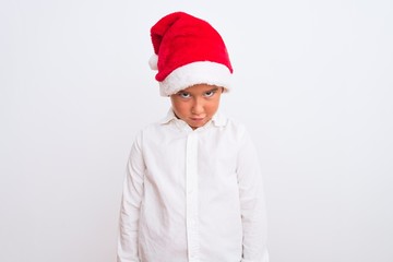 Sticker - Beautiful kid boy wearing Christmas Santa hat standing over isolated white background skeptic and nervous, frowning upset because of problem. Negative person.