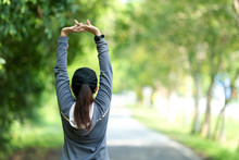 Healthy Woman Warming Up Stretching Her Arms. Asian Runner Woman Workout Before Fitness And Jogging Session On The Road Nature Park. Healthy And Lifestyle Concept