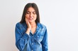 © Krakenimages.com - Young beautiful woman wearing casual denim shirt standing over isolated white background touching mouth with hand with painful expression because of toothache or dental illness on teeth