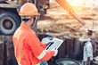 © nikomsolftwaer - Asian engineer with hardhat using tablet inspecting and working at construction site