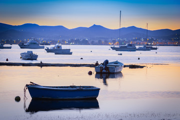 Wall Mural - Greece, majestic traditional view on Aegean sea. Dramatic Greek view of traditional scene: wooden fishing boats during twilight at mountain hills background. Summer vacations in Greece background.