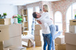 © Krakenimages.com - Young beautiful couple hugging at new home around cardboard boxes