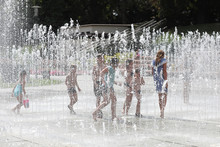 Happy Children Playing Happily In The City Fountain On A Hot Summer Day.
