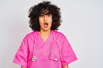 Sticker - Young arab doctor woman with curly hair wearing stethoscope over isolated white background afraid and shocked with surprise expression, fear and excited face.